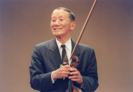 Picture of Dr. Shinichi Suzuki with violin